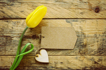 Wall Mural - yellow tulip and paper label on wooden table