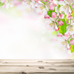 Wall Mural - Wooden table top on blossoming apple tree blurred background