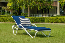 Blue Cushion On White Rattan Sun Lounger In The Green Garden