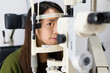© leungchopan - Woman doing eye test in optical clinic