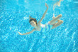 © Iuliia Sokolovska - Child swims in pool underwater, happy active girl jumps, dives and has fun under water, kid sport on family vacation