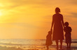 © nadezhda1906 - mother and two kids walking at sunset beach