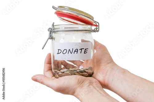 Fotografie, Obraz Hands hold jar with coins and donate label. Isolated on white.