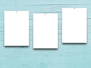 Close-up of three nailed blank frames on aqua wooden boards background