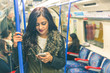 © william87 - Young indian woman using smart phone in the tube