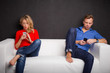Couple sitting on couch with their phones in their hand