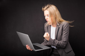 Woman being angry and holding computer