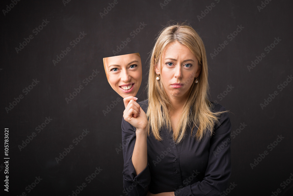 Woman holding mask of her happy face