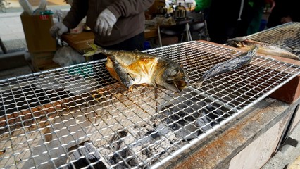 魚の干物を網焼きにしている