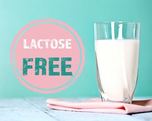 Canvas Print - pitcher of milk on wooden table and lactose free sign on blue background