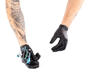 Wall Mural - Tattooist hands in black gloves with tattoo machine isolated on white background, close up