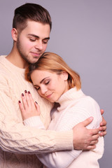 Wall Mural - Young couple in love embracing on grey background