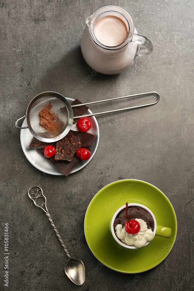 Chocolate cake in a mug served on a dark surface, top view