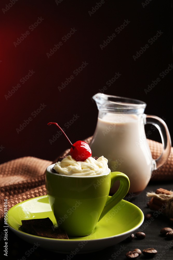 Chocolate cake in a green mug with a cherry on a dark background, close up
