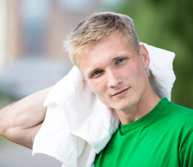 Tired man after fitness time and exercising. With white towel