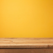 Empty Wooden Deck Table Over Yellow Wallpaper Background
