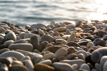 Sea Gravel Shore Or Beach With Sea Water At Sunset