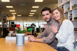 © corepics - Couple With Speaker On Counter In Electronics Shop