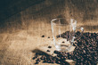 empty glass cup with coffee bean on traditional sack textile. Vintage retouching.