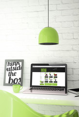 Wall Mural - green desktop with laptop showing online outlet