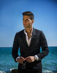 Handsome man in classical suit on beach