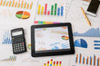 Tablet computer and financial charts, calculator, pen