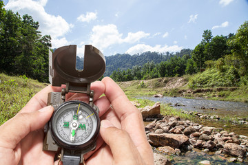 compass in the hand , in  forest background.