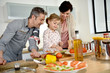 © goodluz - Parents with child cooking together at home