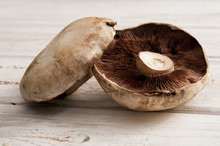 Pair Of Mushrooms On A Wooden Surface