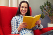 © ArtFamily - smiley young woman resting on the chair with book