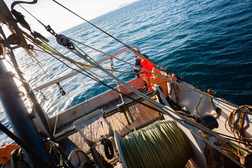 Fishermen standing at the stern of small fishing vessel