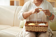 © DragonImages - Cropped image of grandmother knitting at home