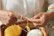 © DragonImages - Hands of senior woman knitting a scarf