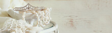 Website Banner Background Of White Pearls Necklace And Diamond Tiara On Vintage Table. Toned Image. Selective Focus
