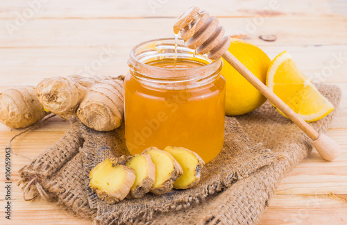Honey comb, fresh lemon and ginger on a wooden table Poster