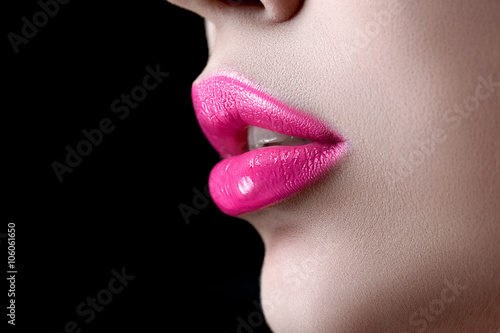 Closeup macro photo of pretty natural lips with pink glossy lipstick on black background Poster