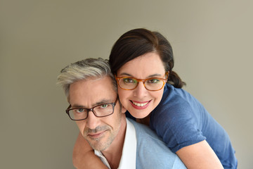 Middle-aged couple with eyeglasses on beige background