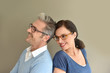 Middle-aged couple with eyeglasses on beige background