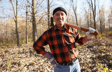 Wall Mural - Portrait of senior lumberjack in nature holding an axe on his shoulder