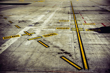 Airport runway with yellow marking lines and lane numbers