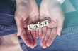 © yiorgosgr - Hands holding Lost message formed with wooden blocks