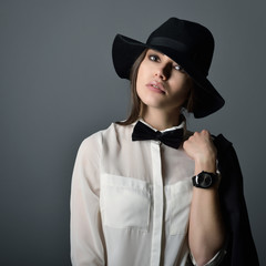 Young beautiful sexy woman in jacket, white shirt, bow-tie and h