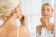 © Syda Productions - woman with lipstick applying make up at bathroom