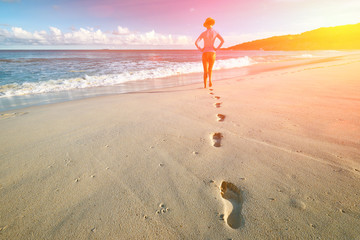 Poster - Woman at beautiful beach. Focus on footprints.