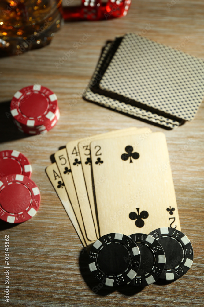 Set to playing poker with cards and chips on wooden table, top view