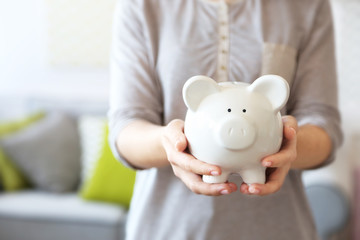 Female hands holding piggy bank closeup