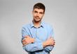 © Africa Studio - Young man standing in blue shirt on grey background