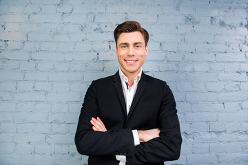 Portrait of handsome businessman with beaming smile and crosed h