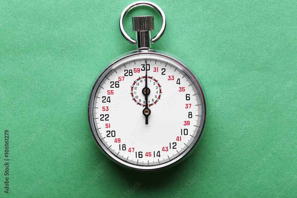 Stopwatch on green  background, close up