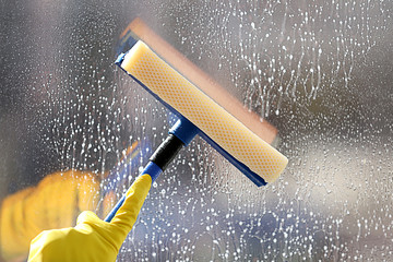 Wall Mural - Cleaning a glass with a squeegee, close up